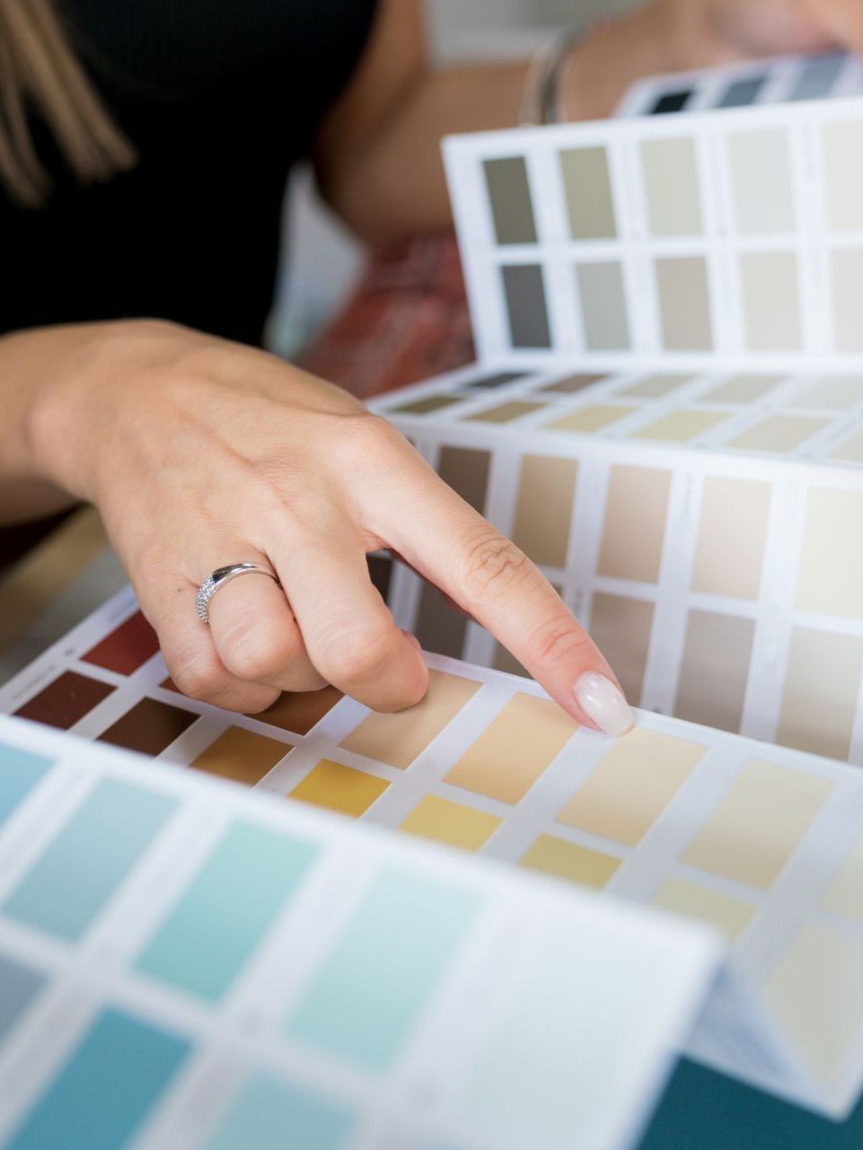 A woman is looking at a palette of paint colors.