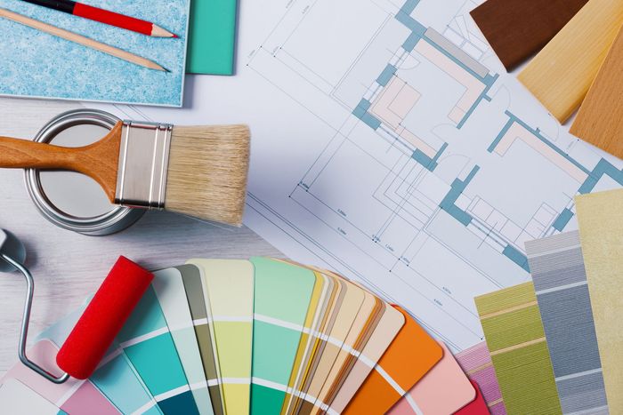 A paint brush is sitting on top of a palette of paint samples.