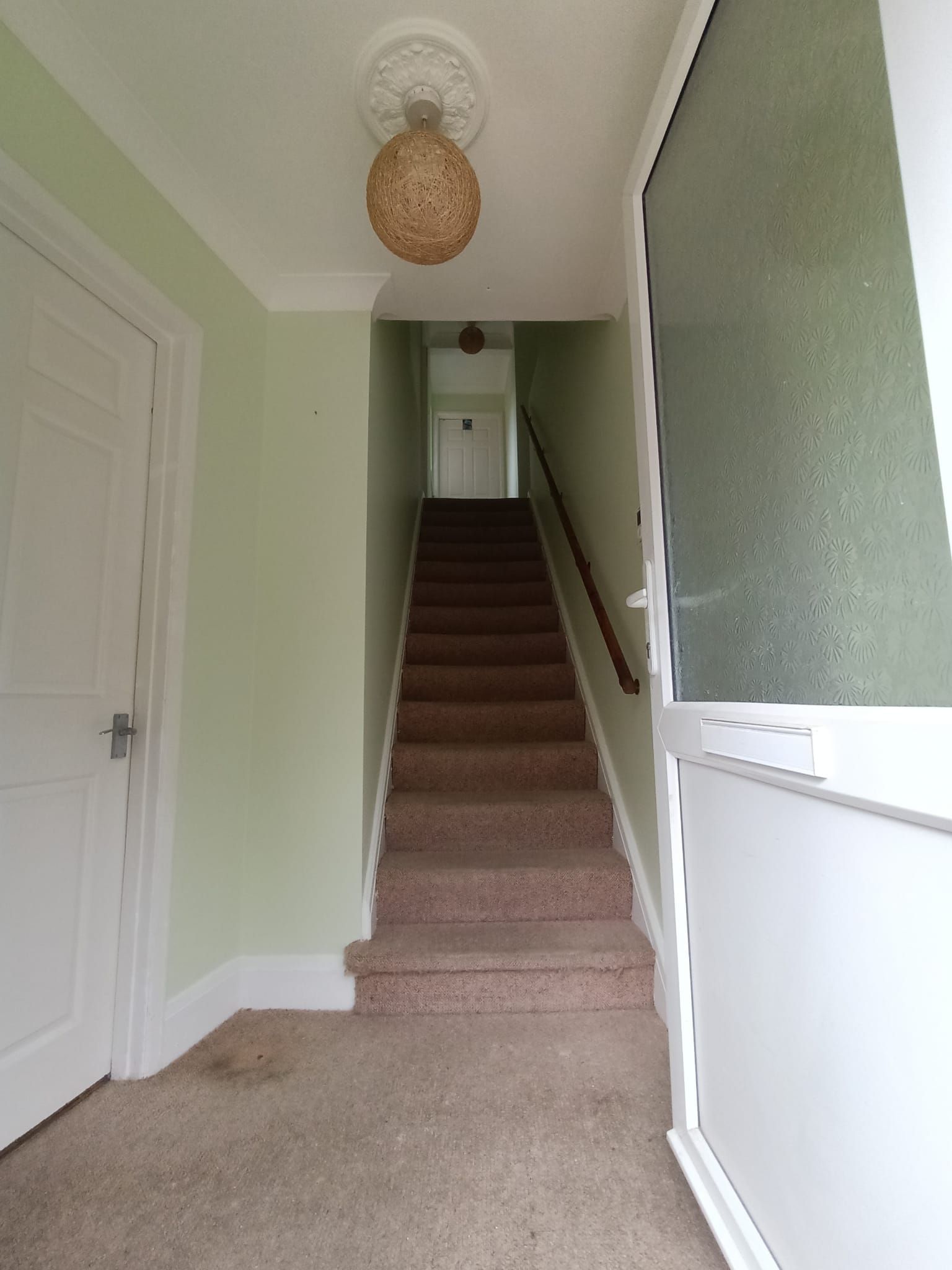 A hallway with stairs leading up to the second floor