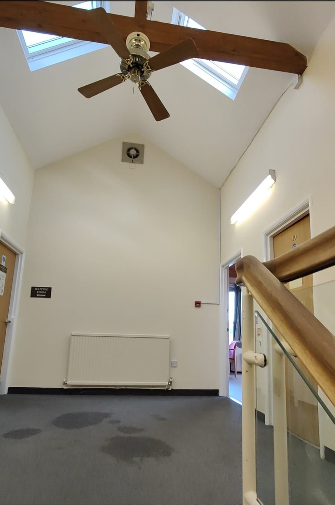 An empty room with a ceiling fan and stairs