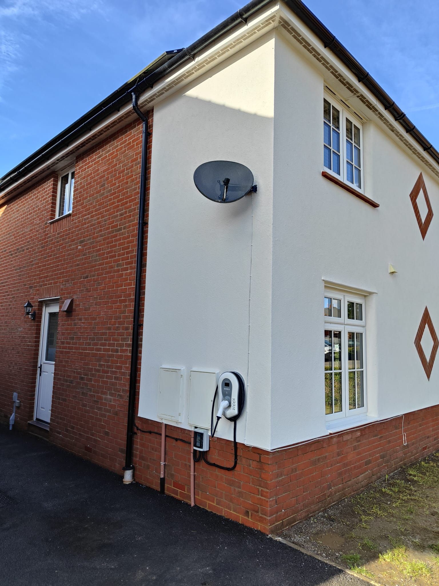 A white house with a satellite dish on the side of it