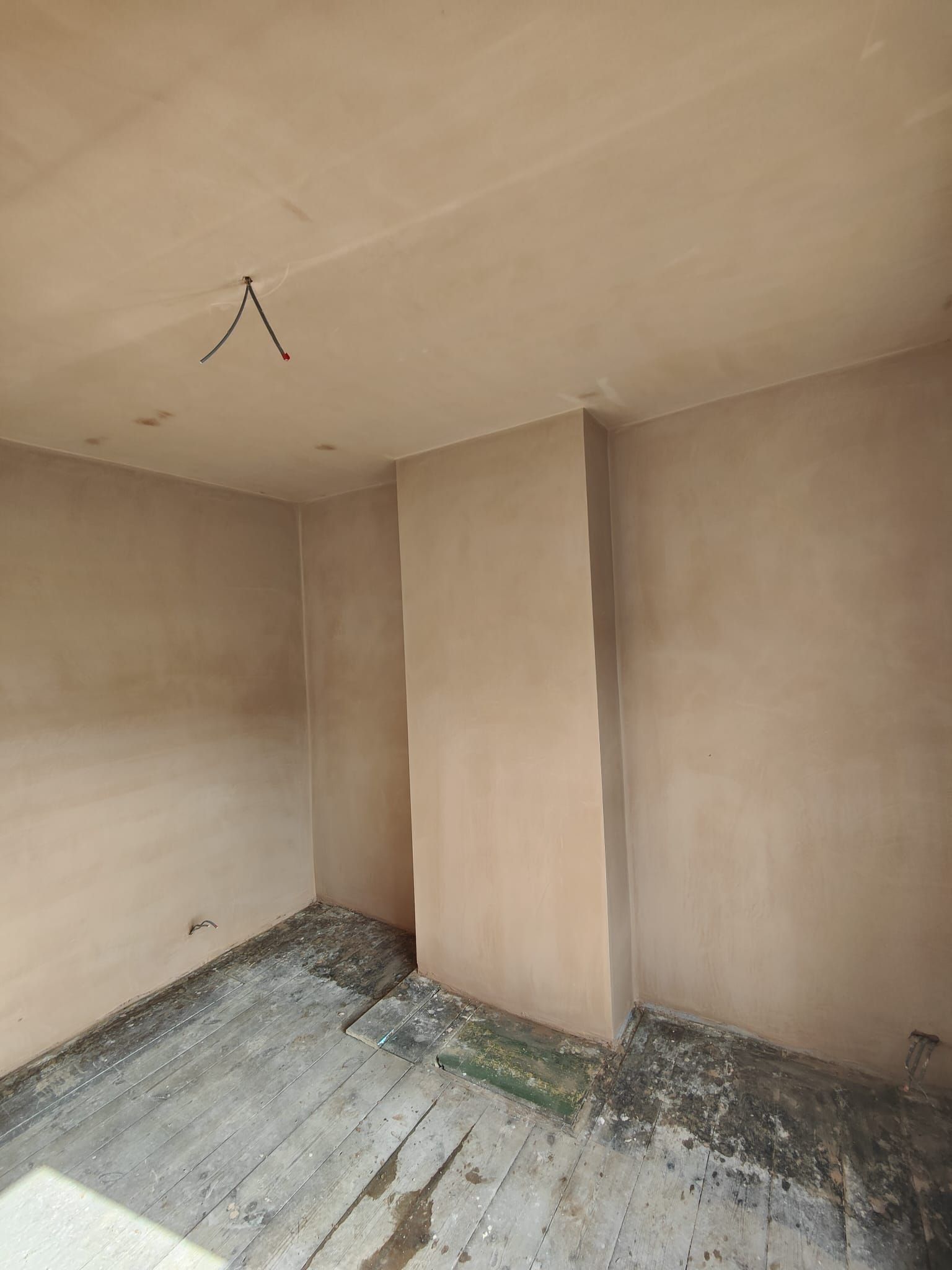 An empty room with a wooden floor and a ceiling.