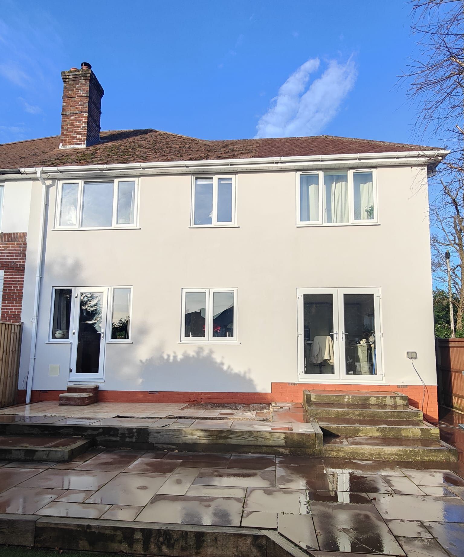 The back of a white house with stairs leading up to it