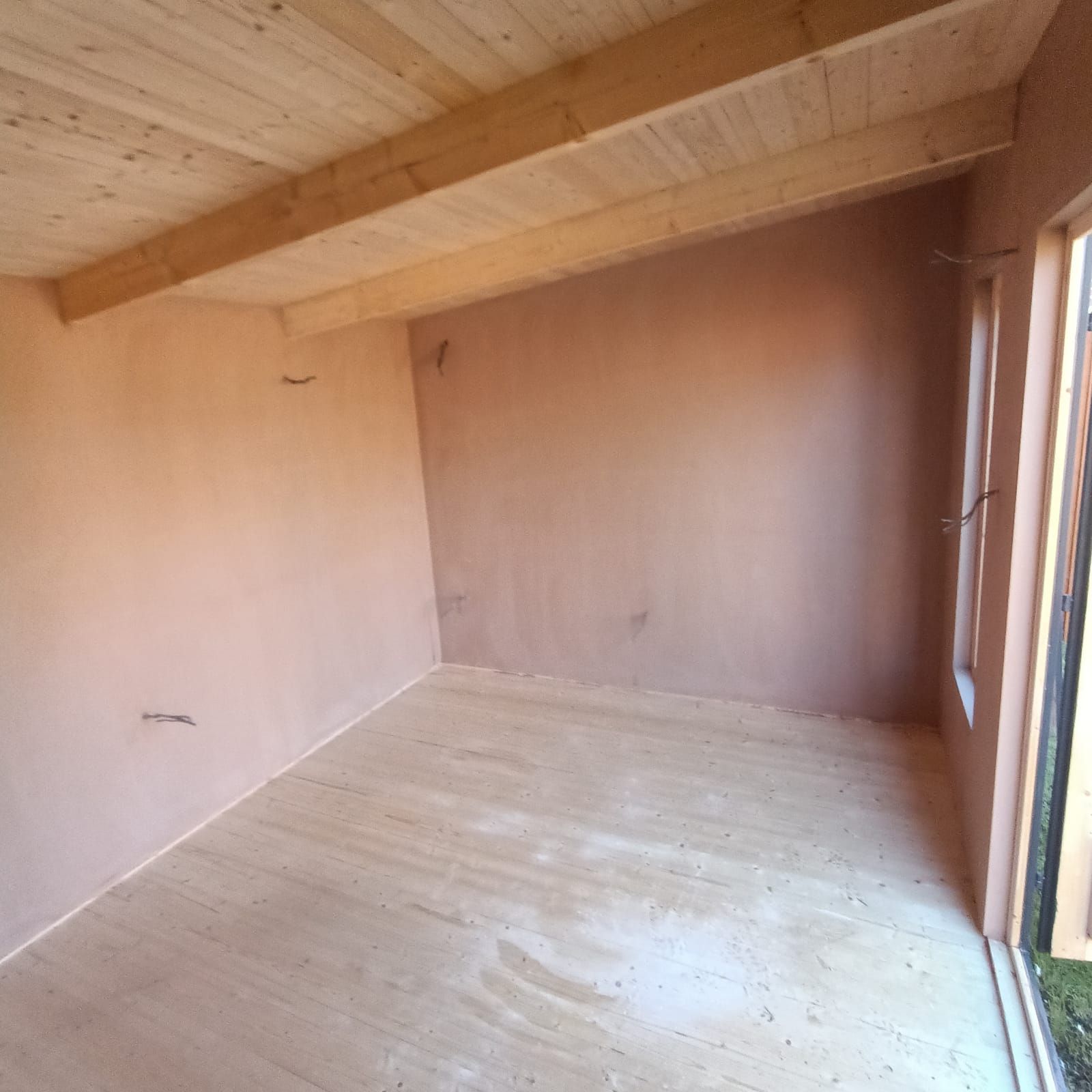 An empty room with wooden floors and a wooden ceiling