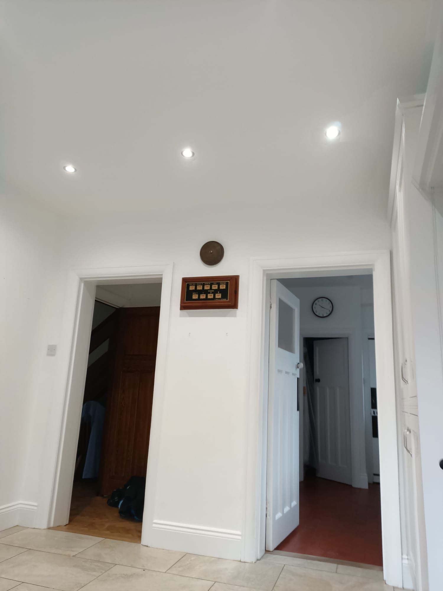 A hallway with two doors and a clock on the wall