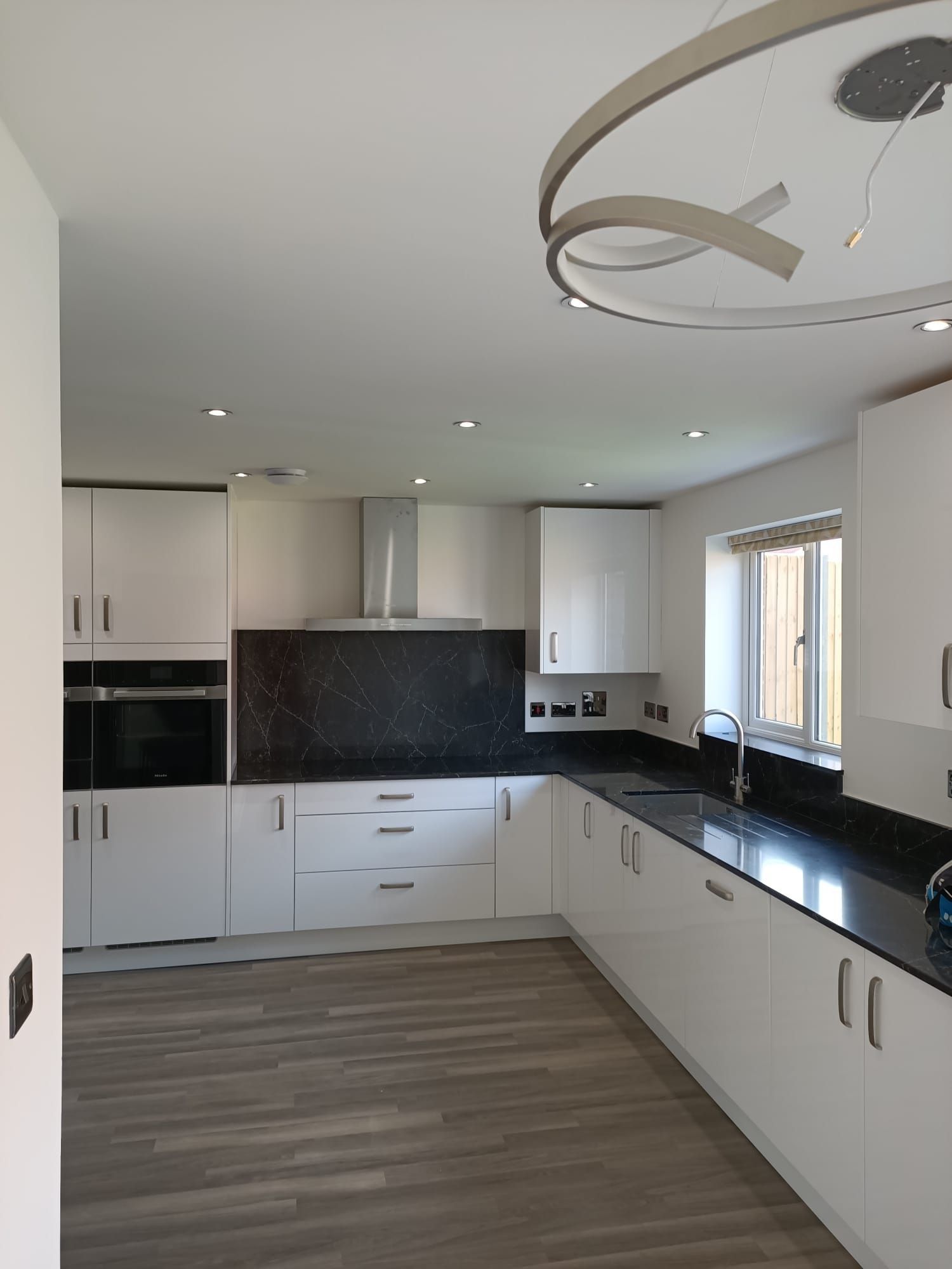 A kitchen with white cabinets and black counter tops