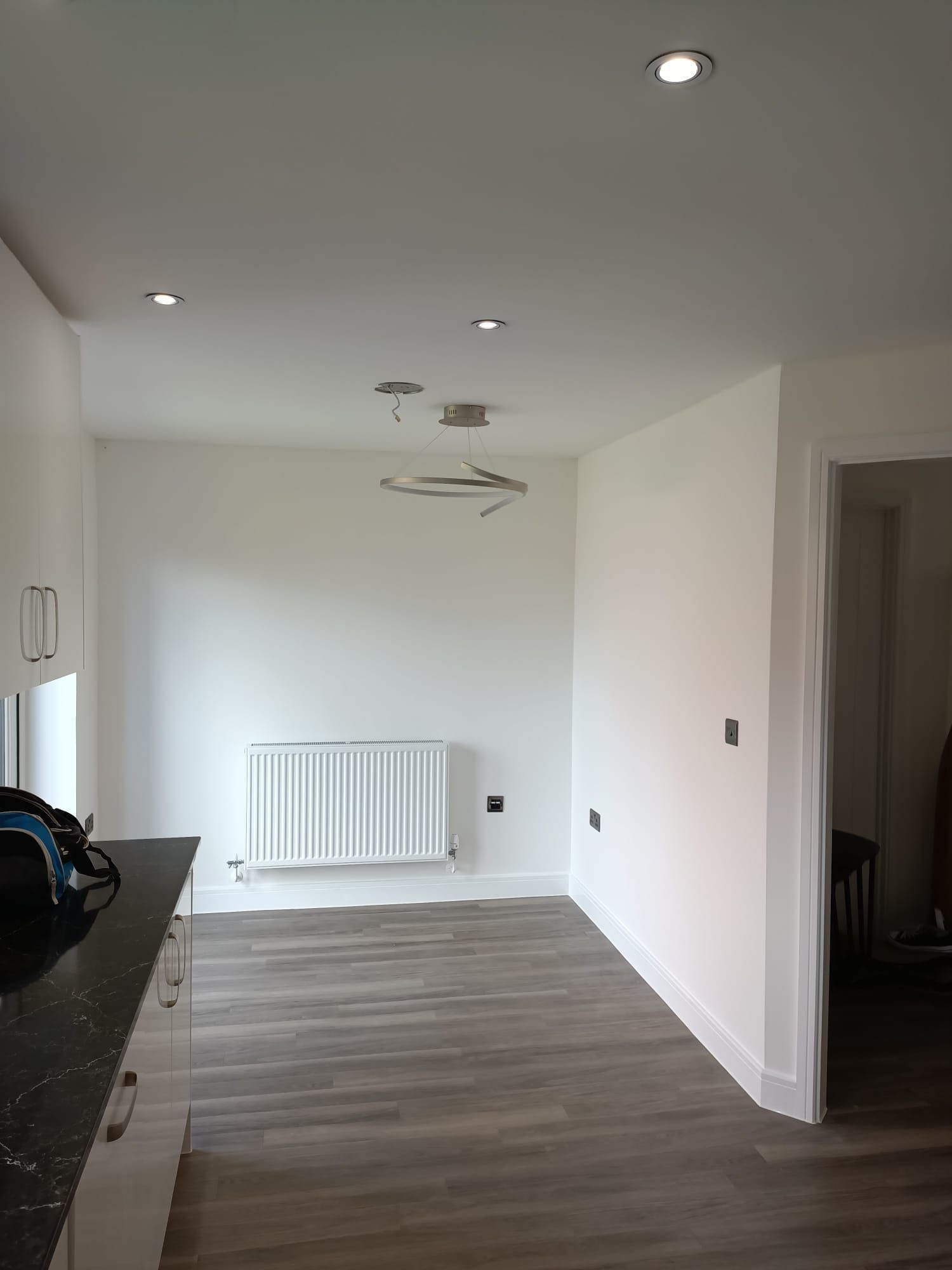 A kitchen with white cabinets and a radiator on the wall.