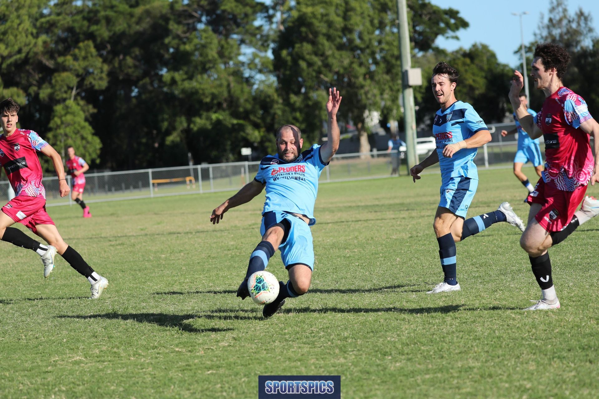 A group of men are playing soccer on a field.