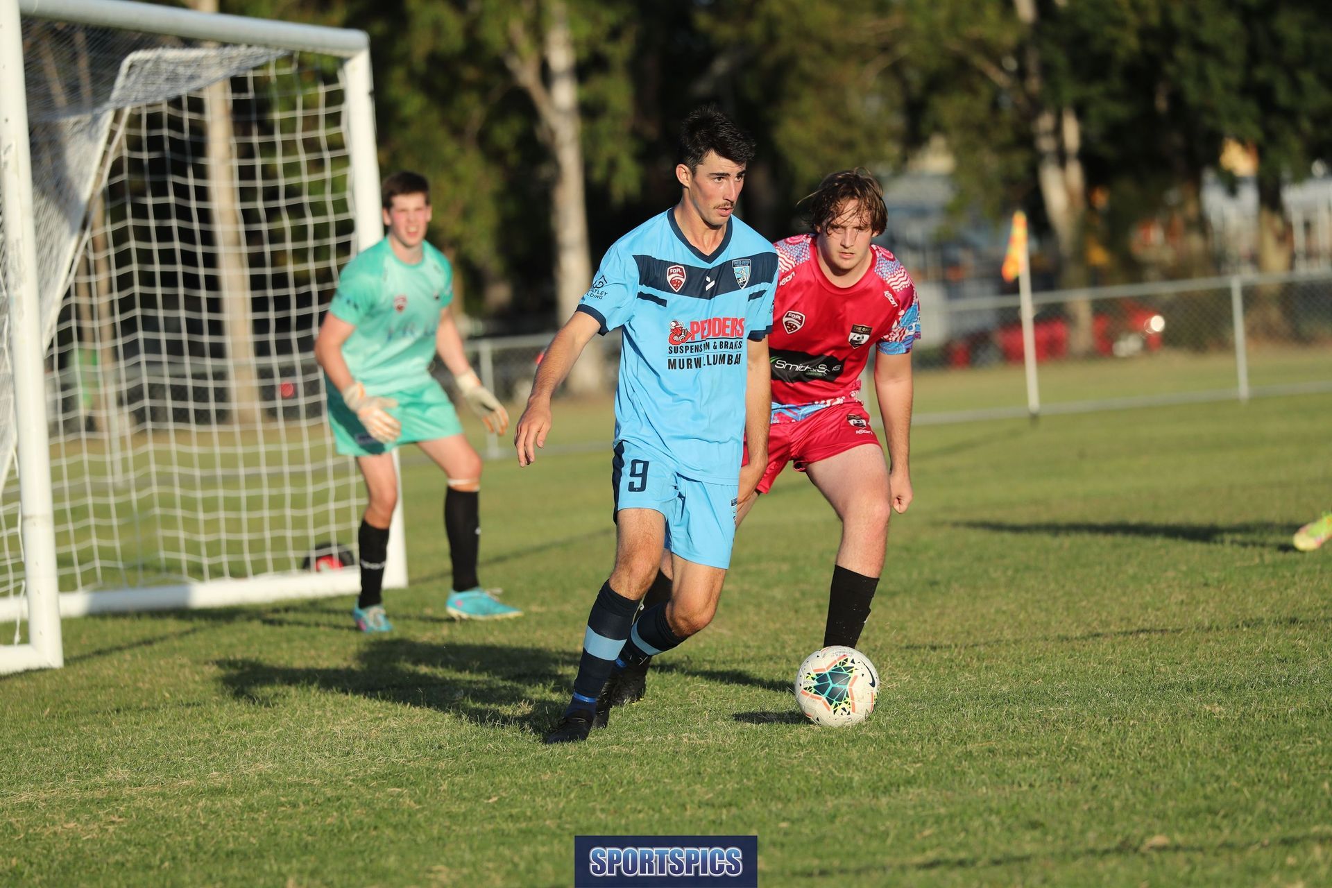 tweed united footballer passing the ball away from goal