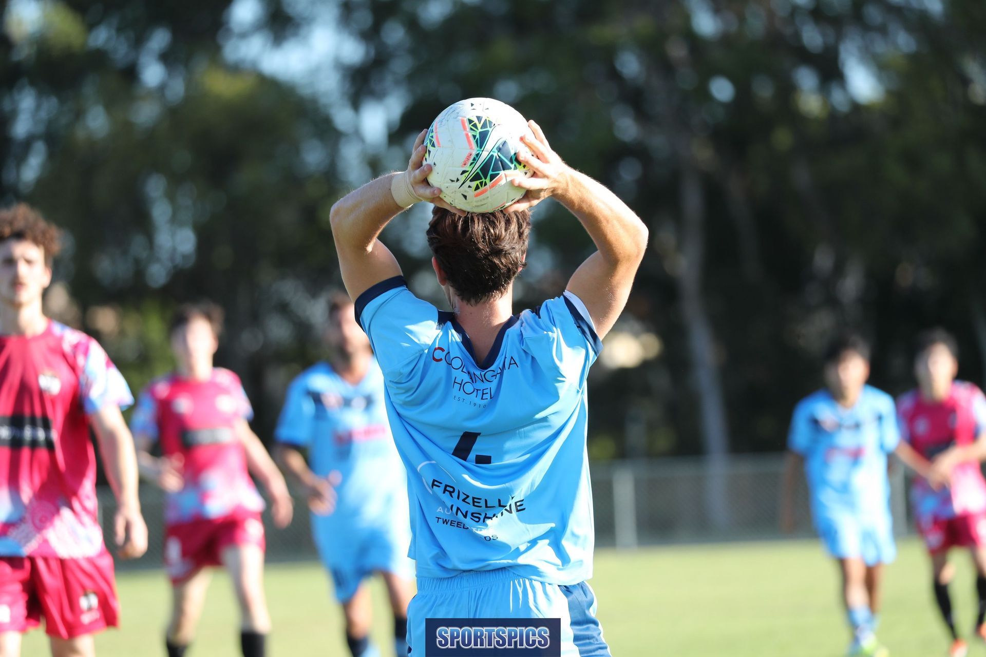 tweed united footballer throwing the ball in