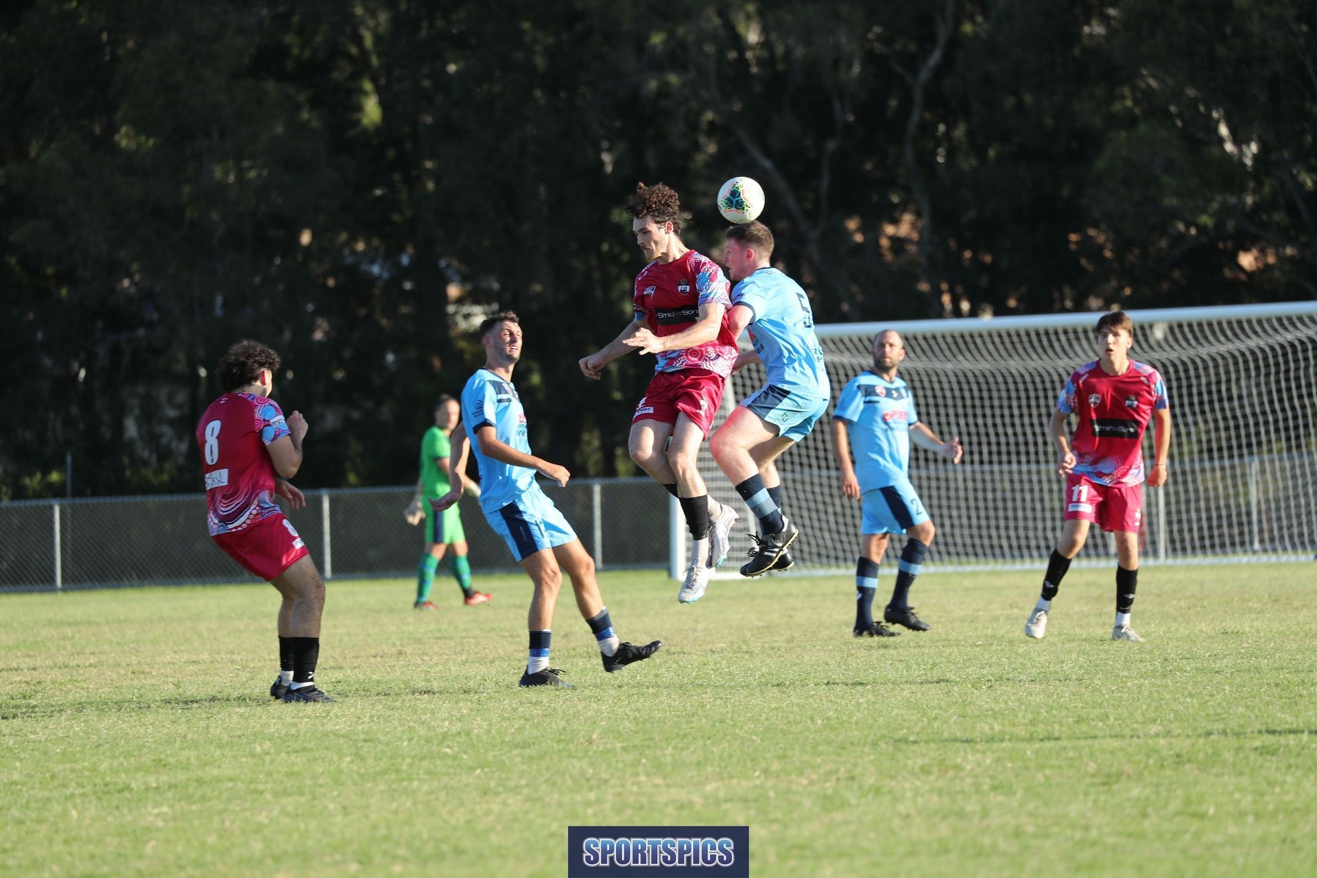 tweed united footballer heading the ball from opposition