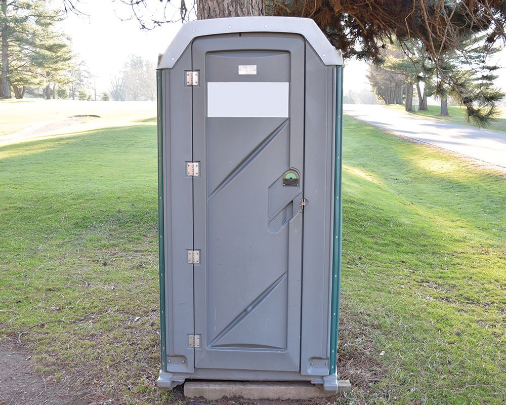 A portable toilet on grass near a road in Gulfport, MS, from Portable Services Inc. Portable Toilet 