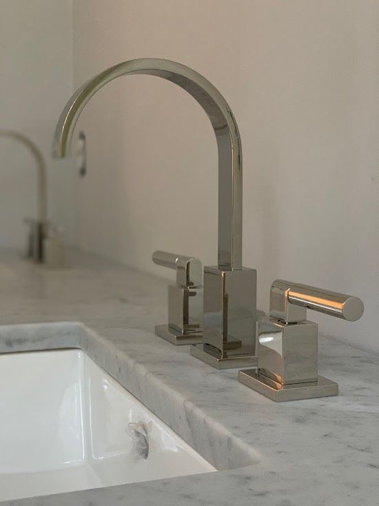A bathroom sink with a chrome faucet on top of it