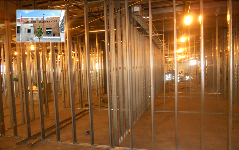 Empty building interior with exposed metal framing and bright construction lights.