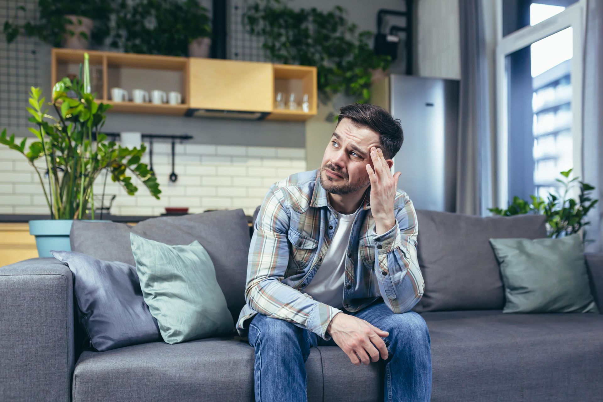 A man and a woman are sitting on a couch having an argument.
