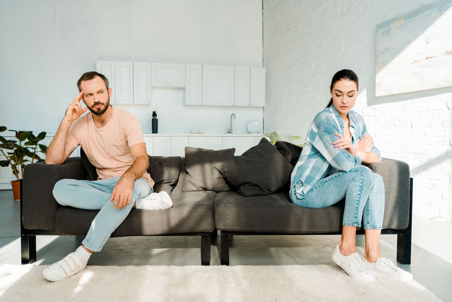Couple sitting apart contemplating relationship repair after betrayal - Karen Collins Therapy Petalu