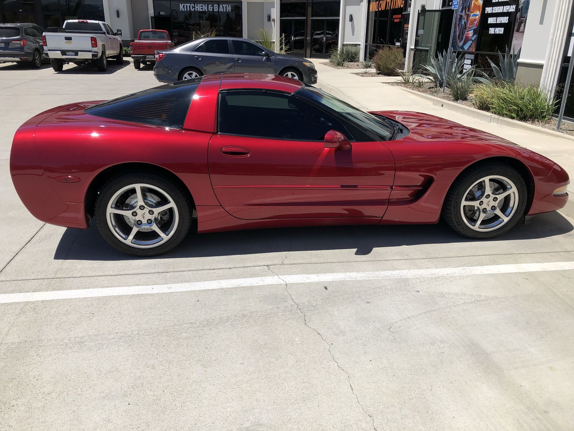 A red corvette is parked in a parking lot.