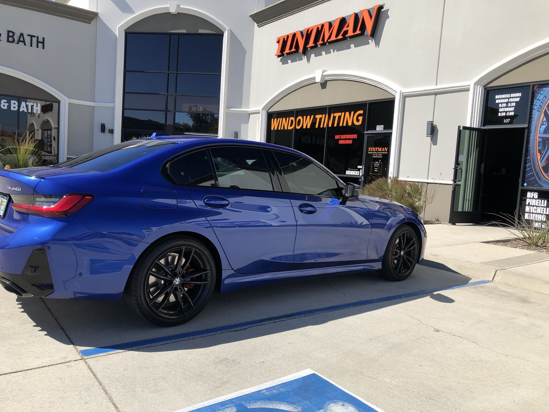 A blue car is parked in front of a building.