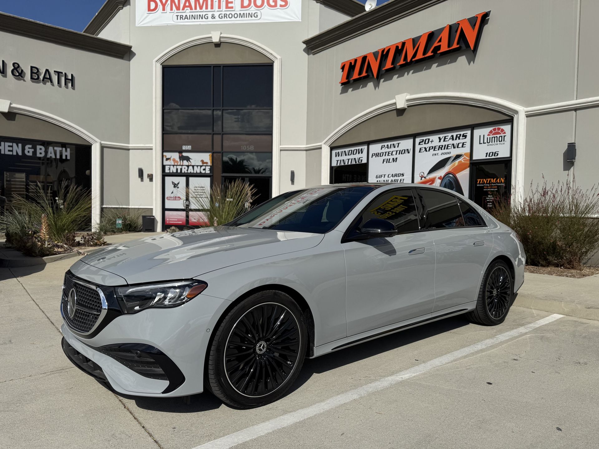 A silver car is parked in front of a building.