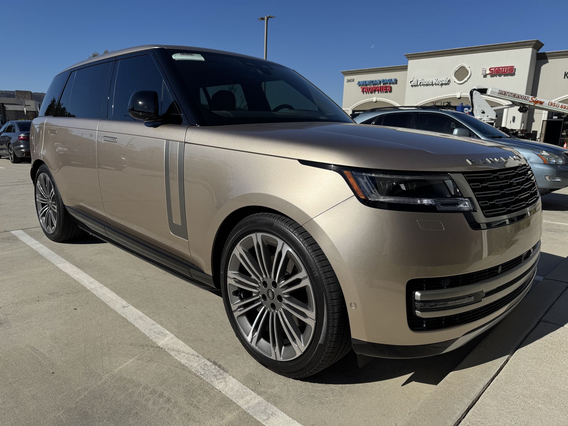 A range rover is parked in a parking lot in front of a building.