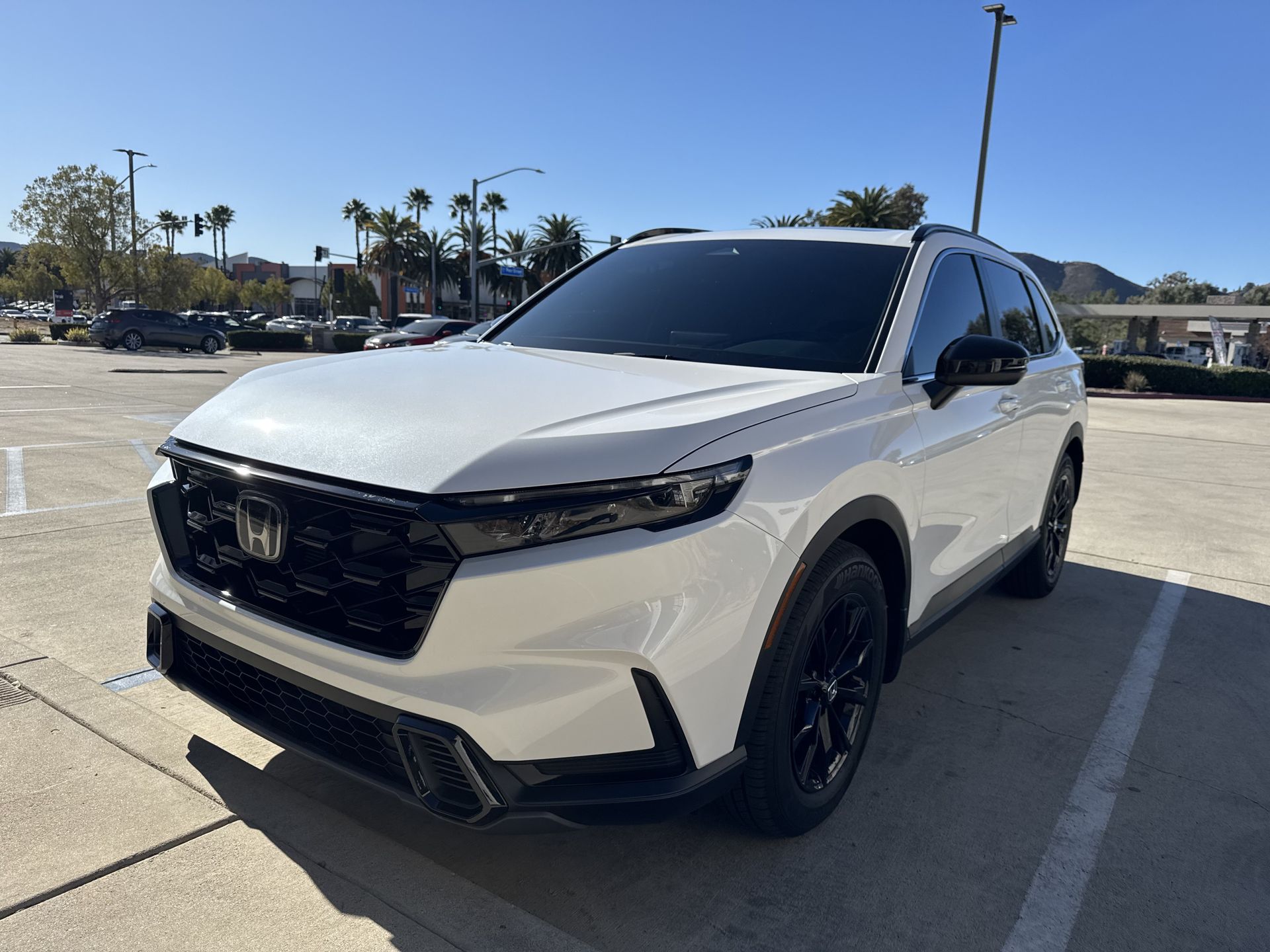 A white honda accord is parked in a parking lot.