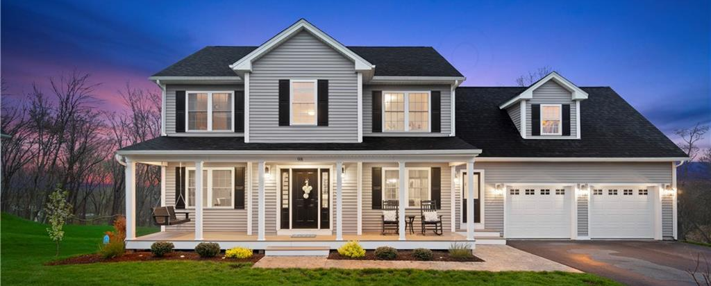 Two-story gray house with black shutters, porch, and attached garage at dusk.