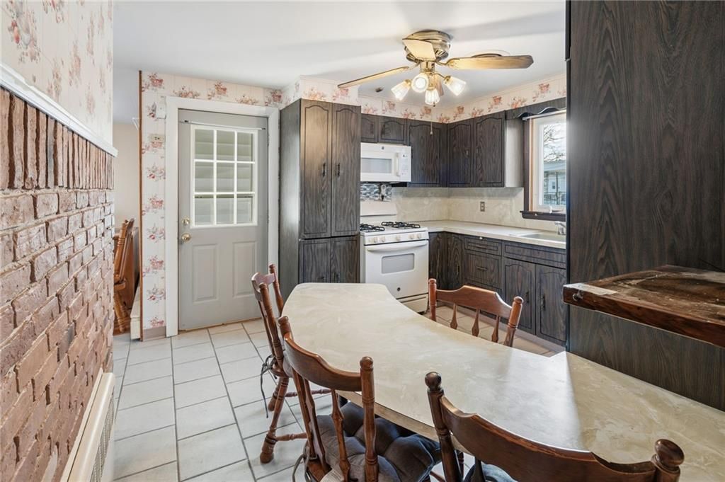 Kitchen with a table and chairs, brick accent wall, and cabinets.