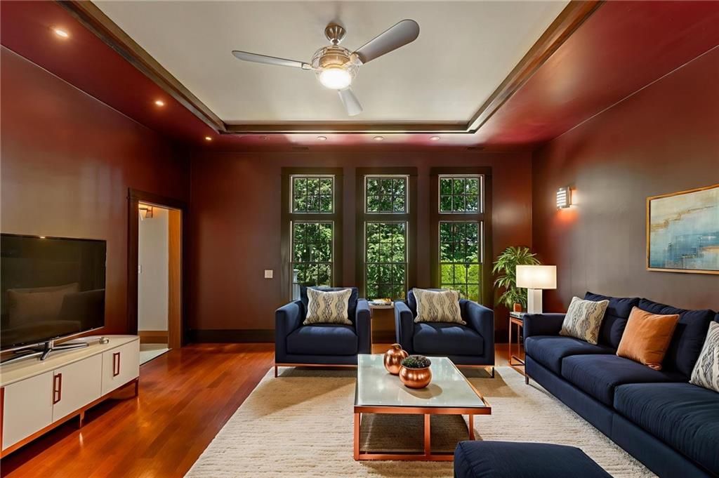 Living room with navy blue furniture, burgundy walls, and a wood floor.