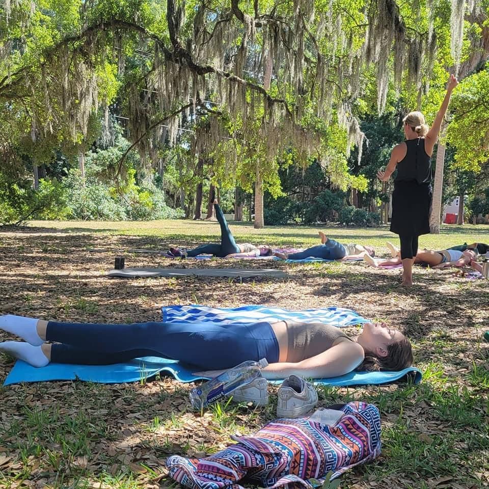 A group of people are doing yoga in a park.