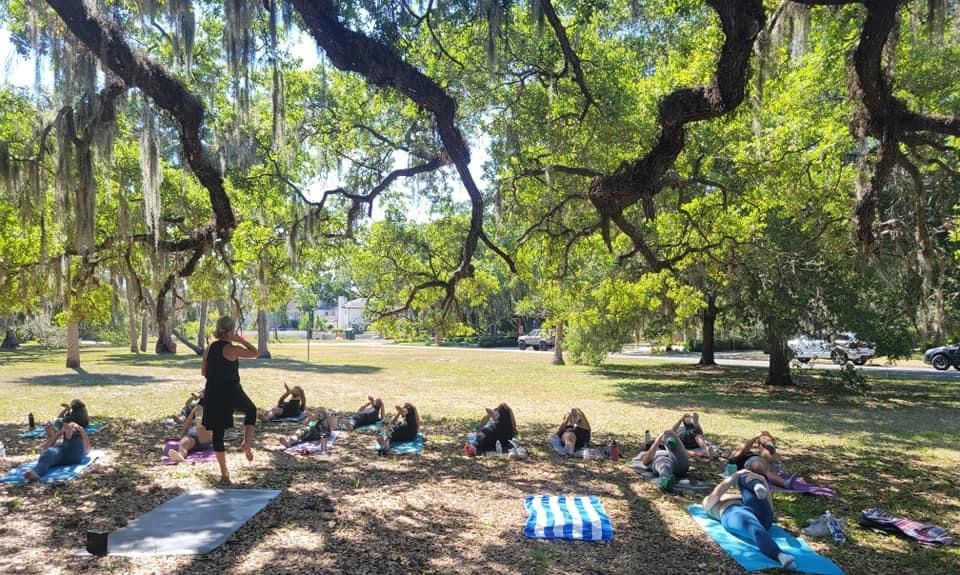 A group of people are doing yoga in a park.