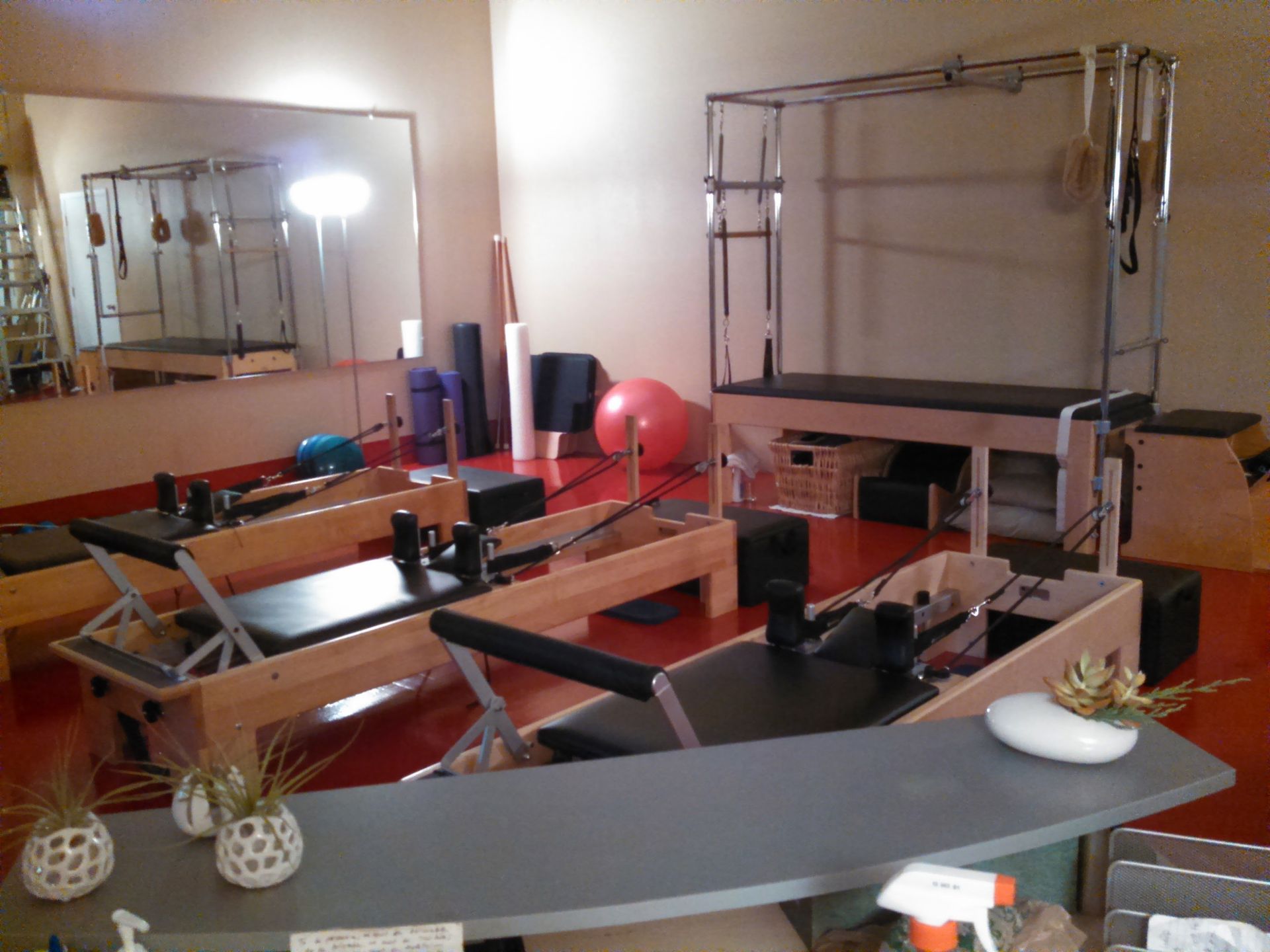A room with a lot of pilates equipment and a spray bottle on the counter