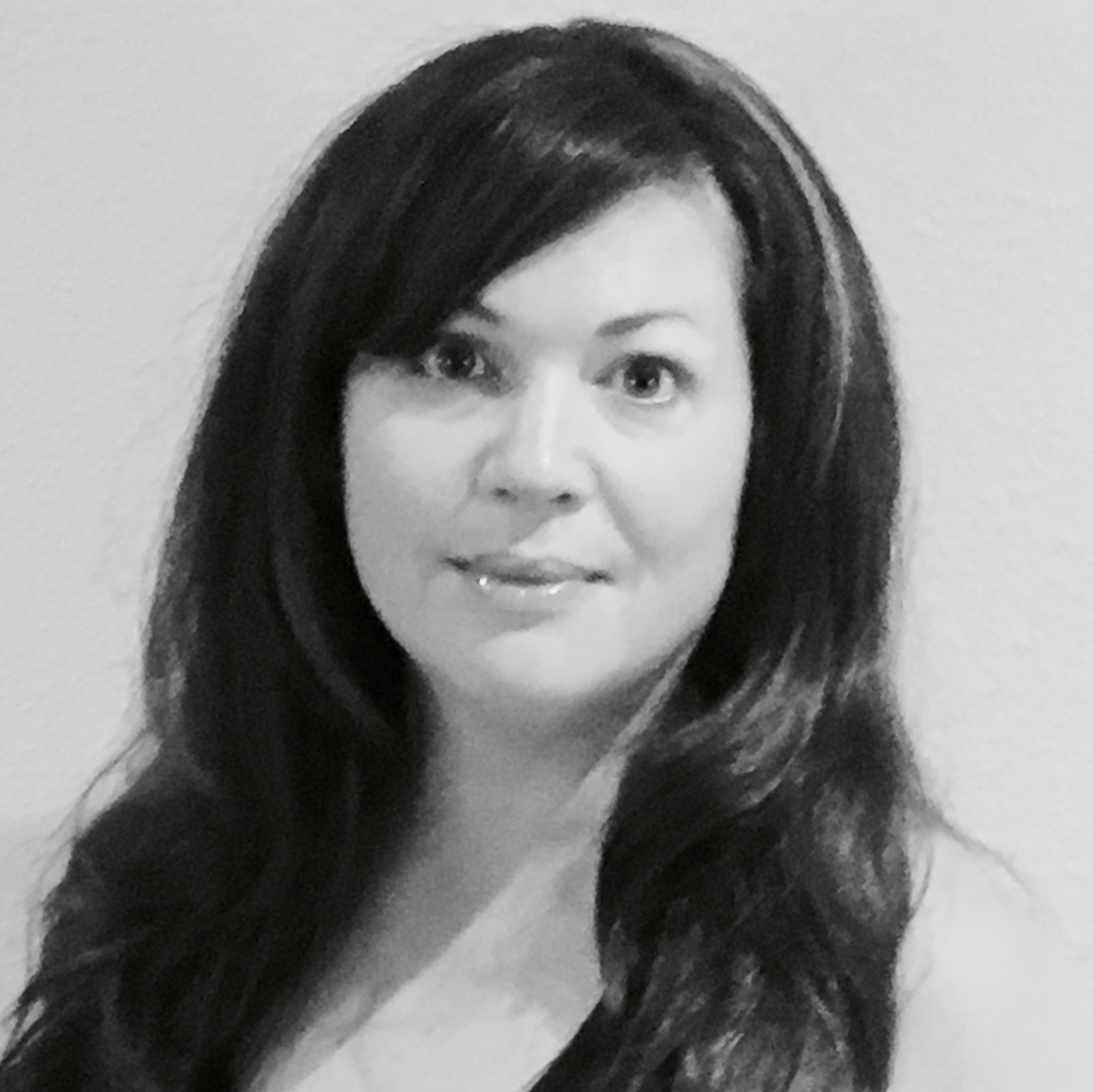 Andrea with long dark hair is smiling in a black and white photo .