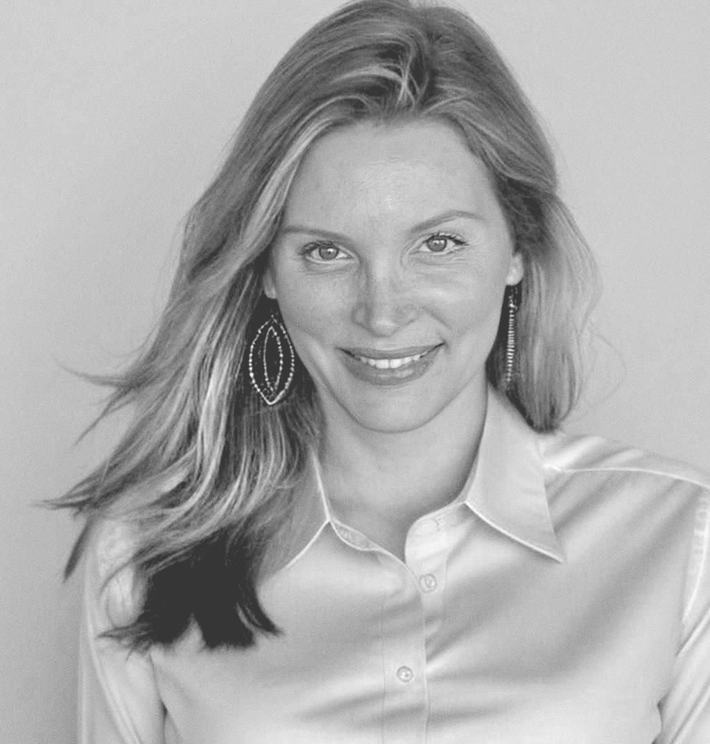 Andra with long hair is smiling in a black and white photo .