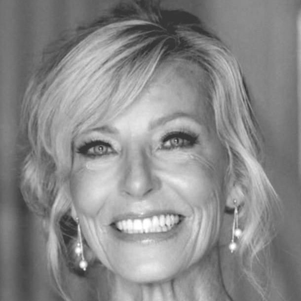 Andra with long hair is smiling in a black and white photo .
