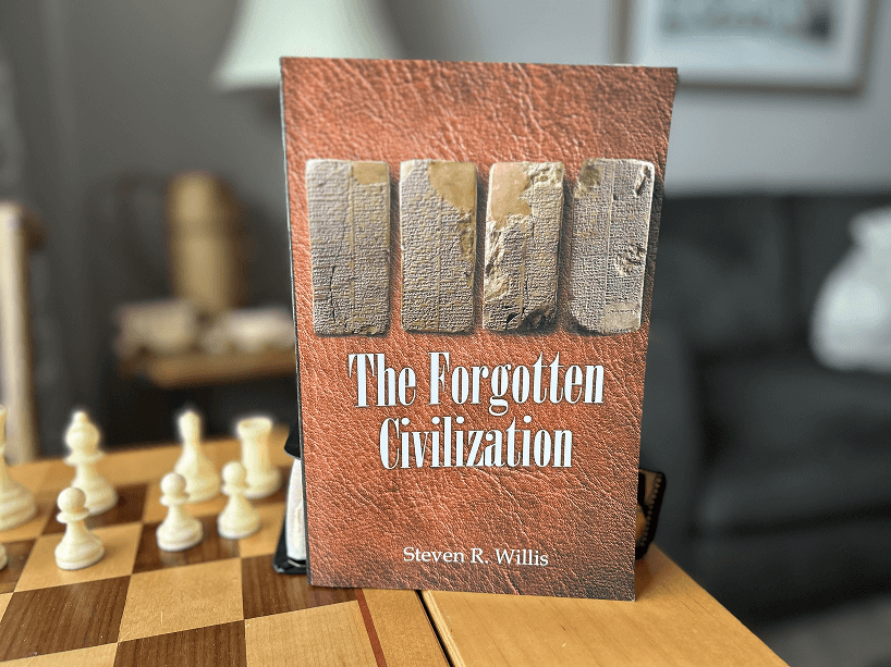 A book titled the forgotten civilization is sitting on a chess board.