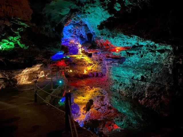 A cave filled with lots of colorful lights at night.