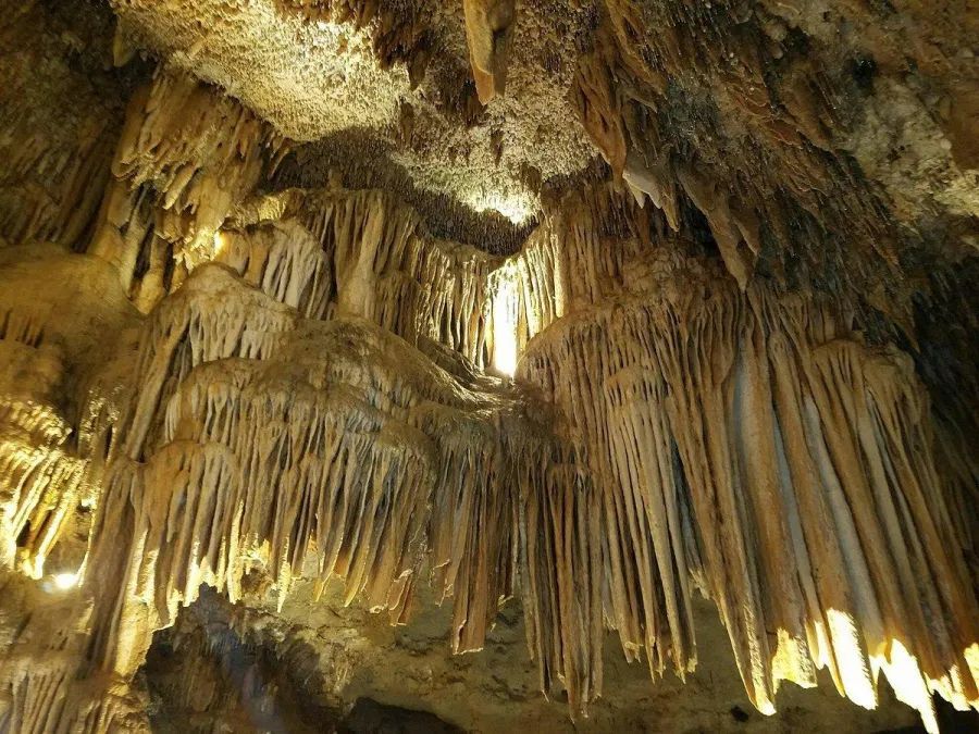 A cave with a lot of stalagmites hanging from the ceiling