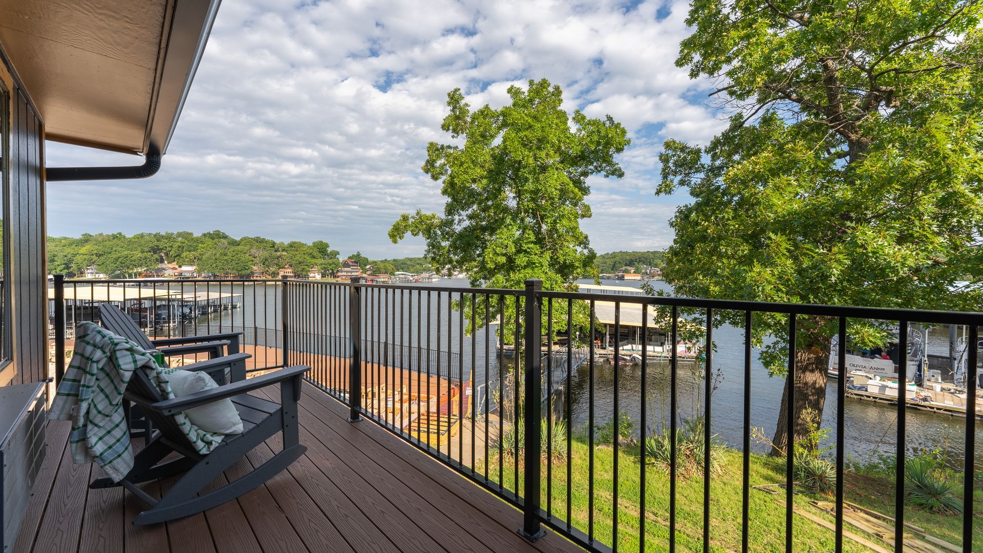 A deck with a rocking chair and a view of a lake.