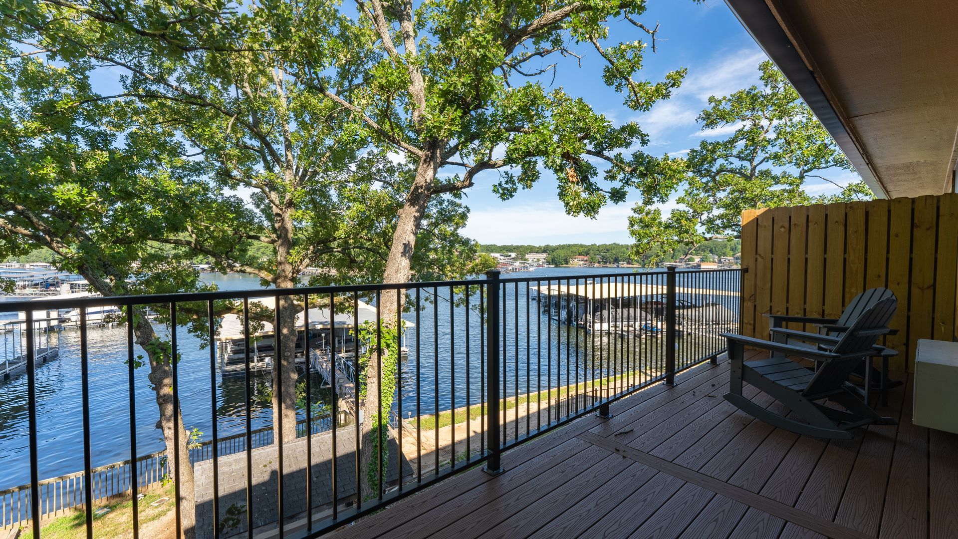 There is a rocking chair on the balcony overlooking the water.