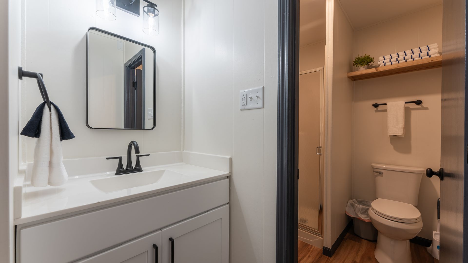 A bathroom with a sink , toilet and mirror.