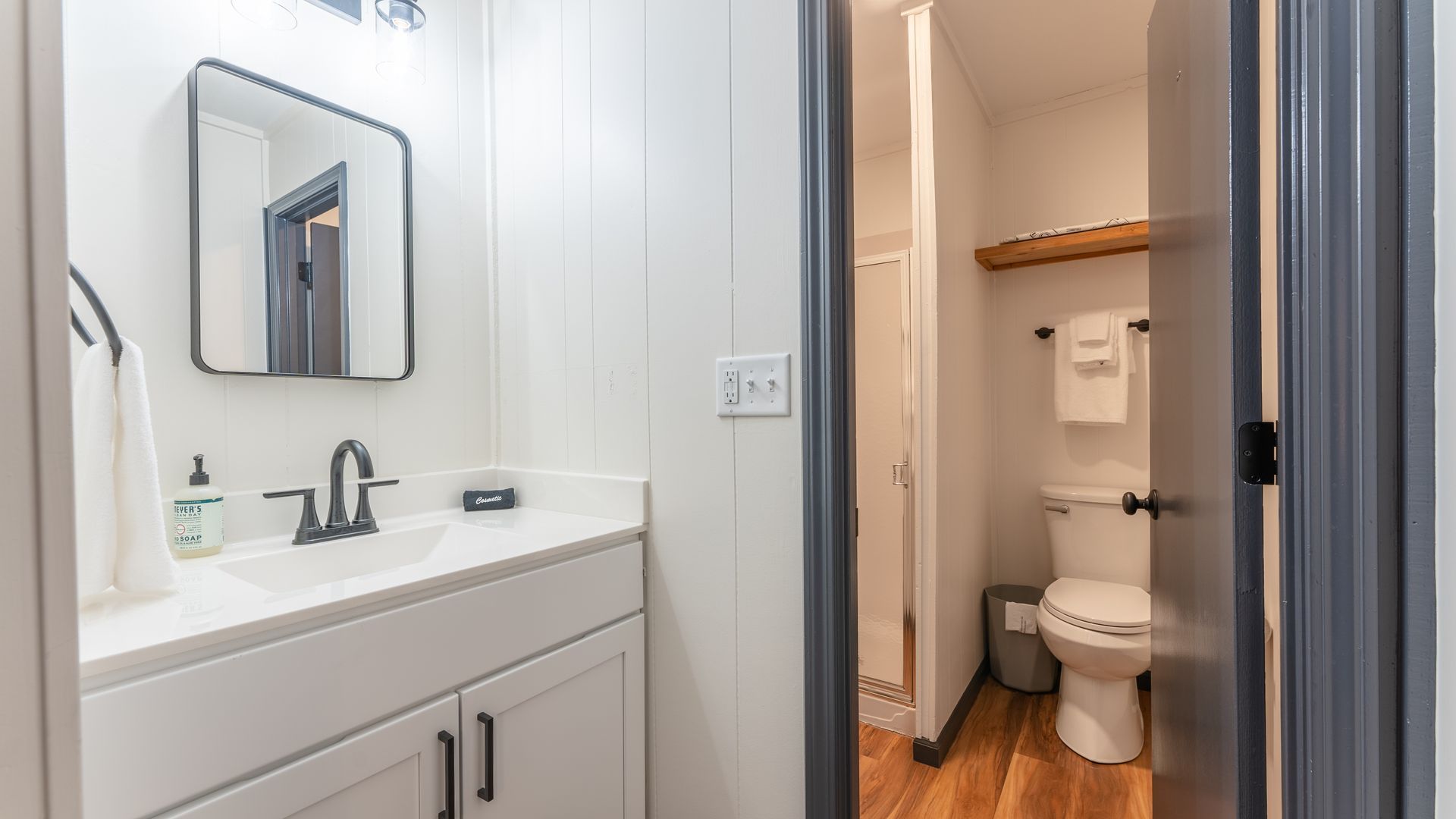 A bathroom with a sink , toilet and mirror.