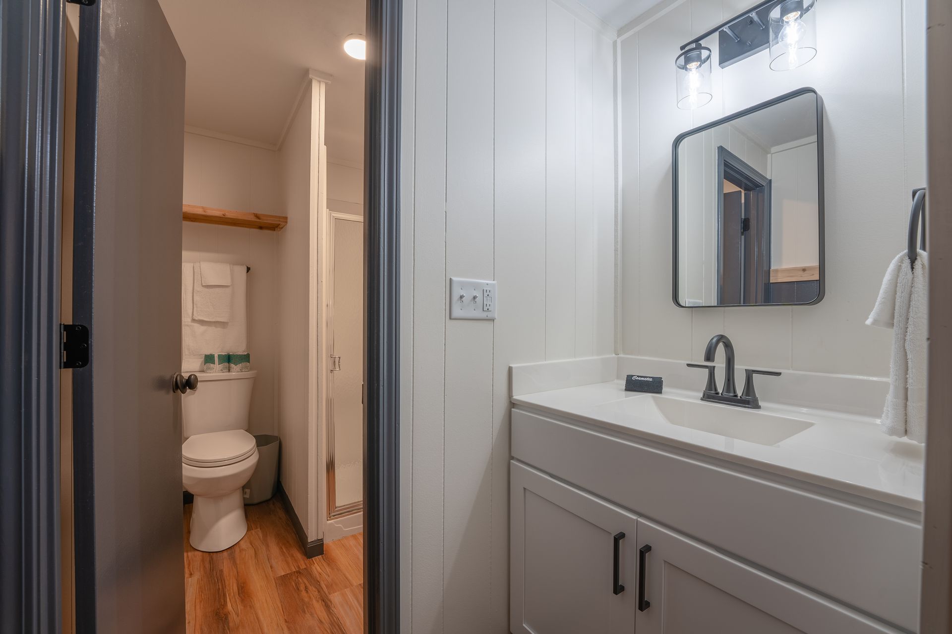 A bathroom with a sink , toilet and mirror.