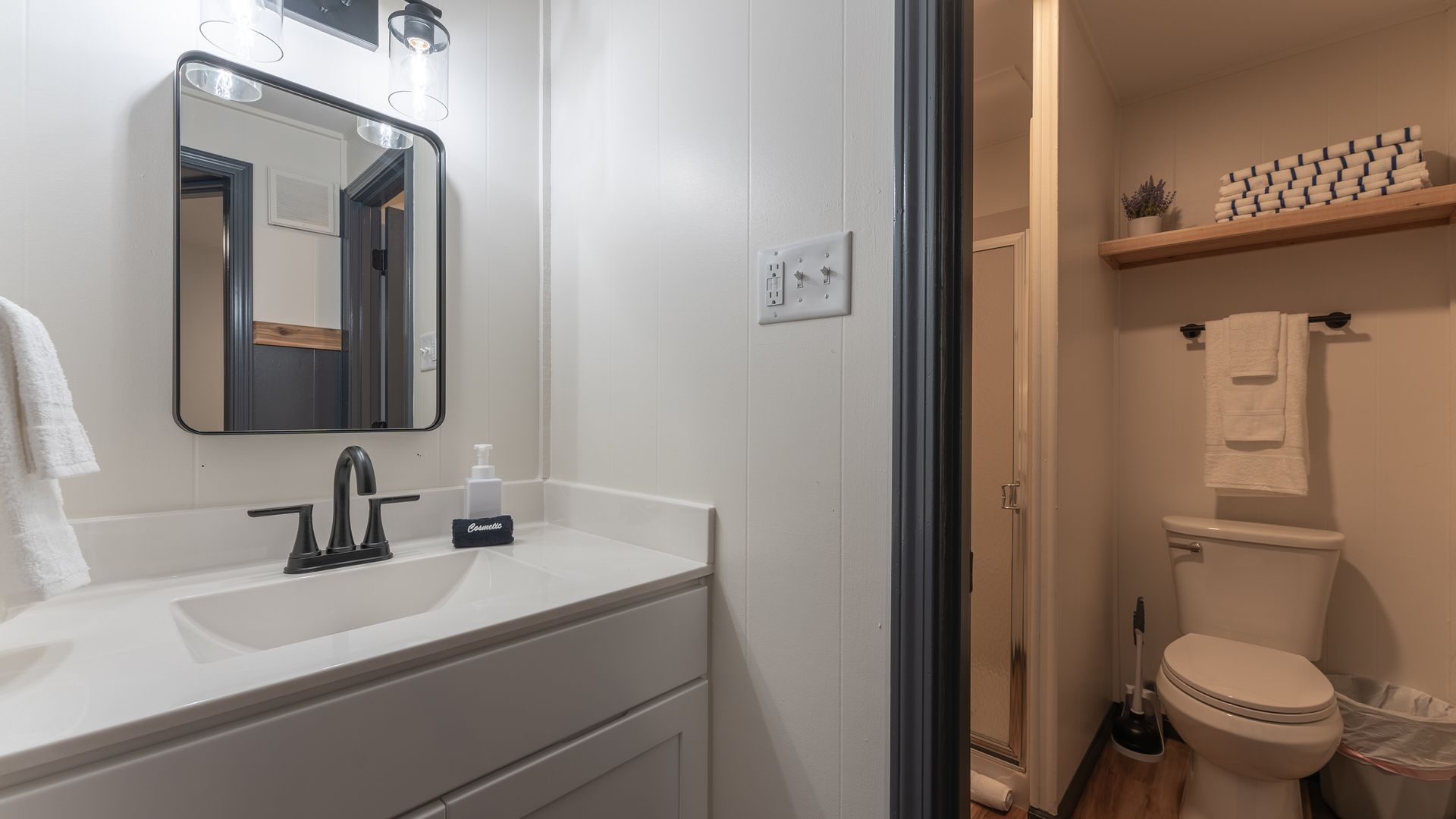 A bathroom with a sink , toilet and mirror.