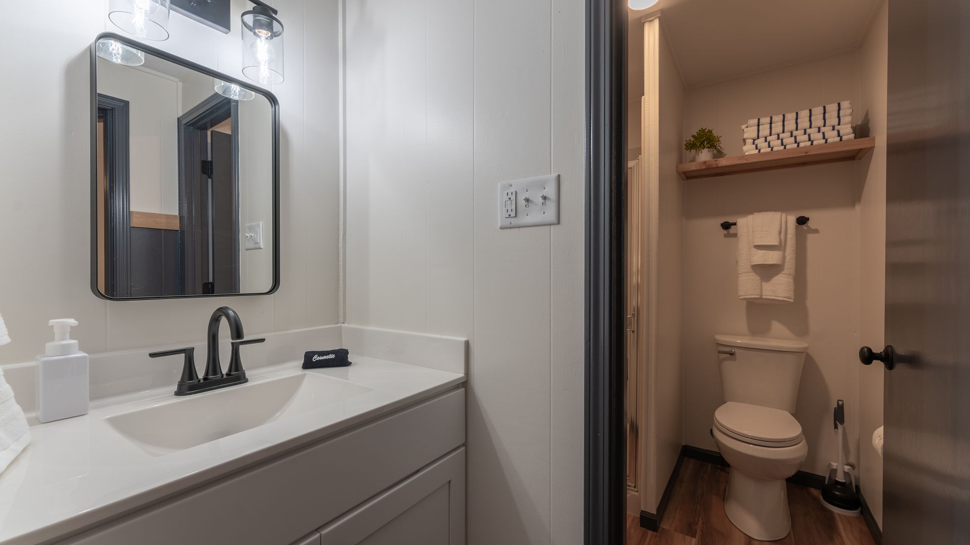 A bathroom with a sink , toilet and mirror.