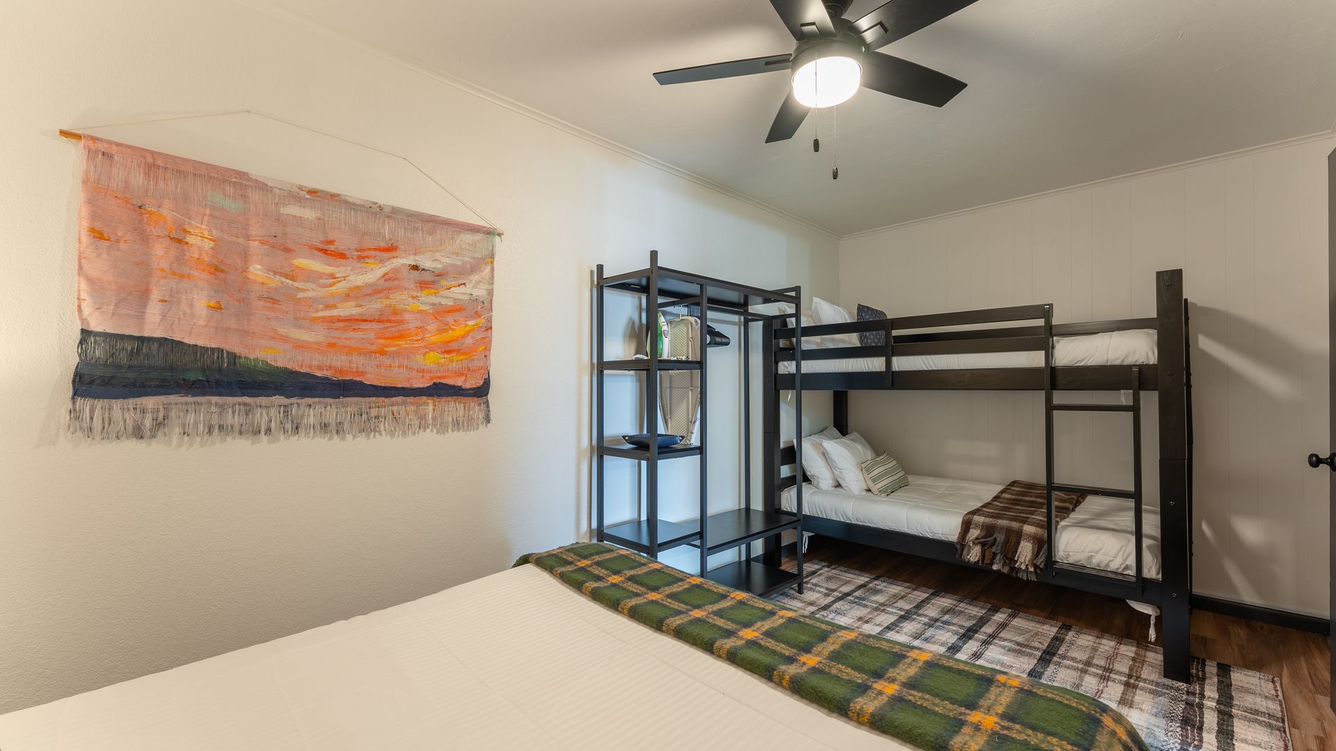 A bedroom with two bunk beds and a ceiling fan.