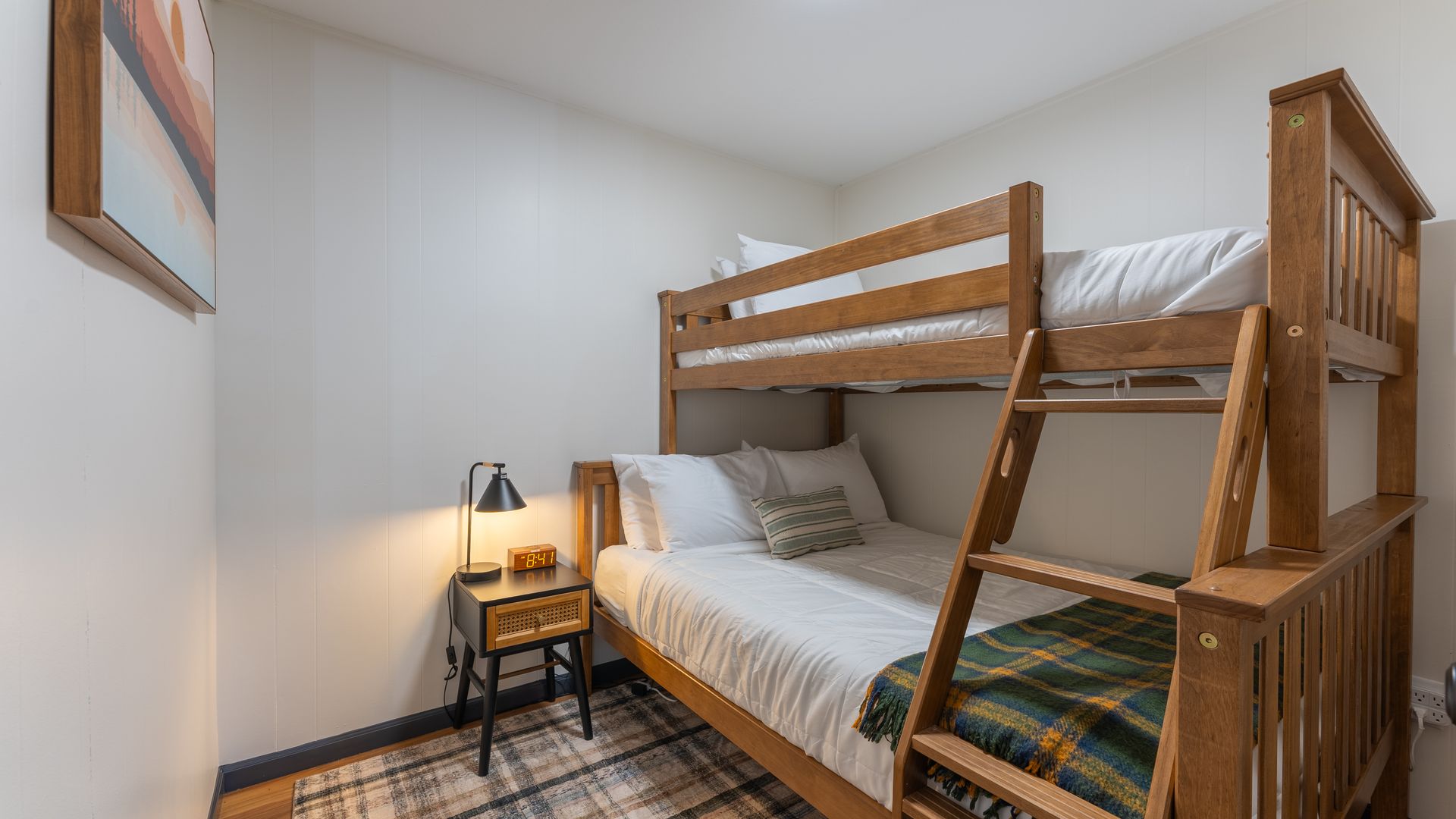 A bedroom with two bunk beds and a nightstand.