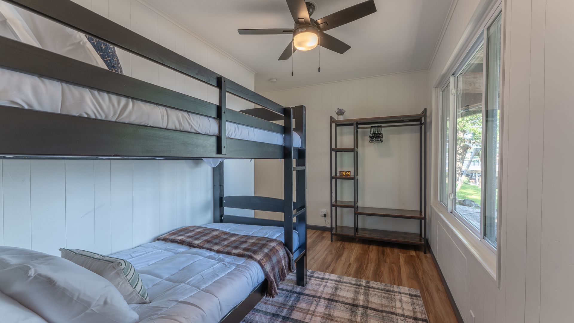 A bedroom with two bunk beds and a ceiling fan.