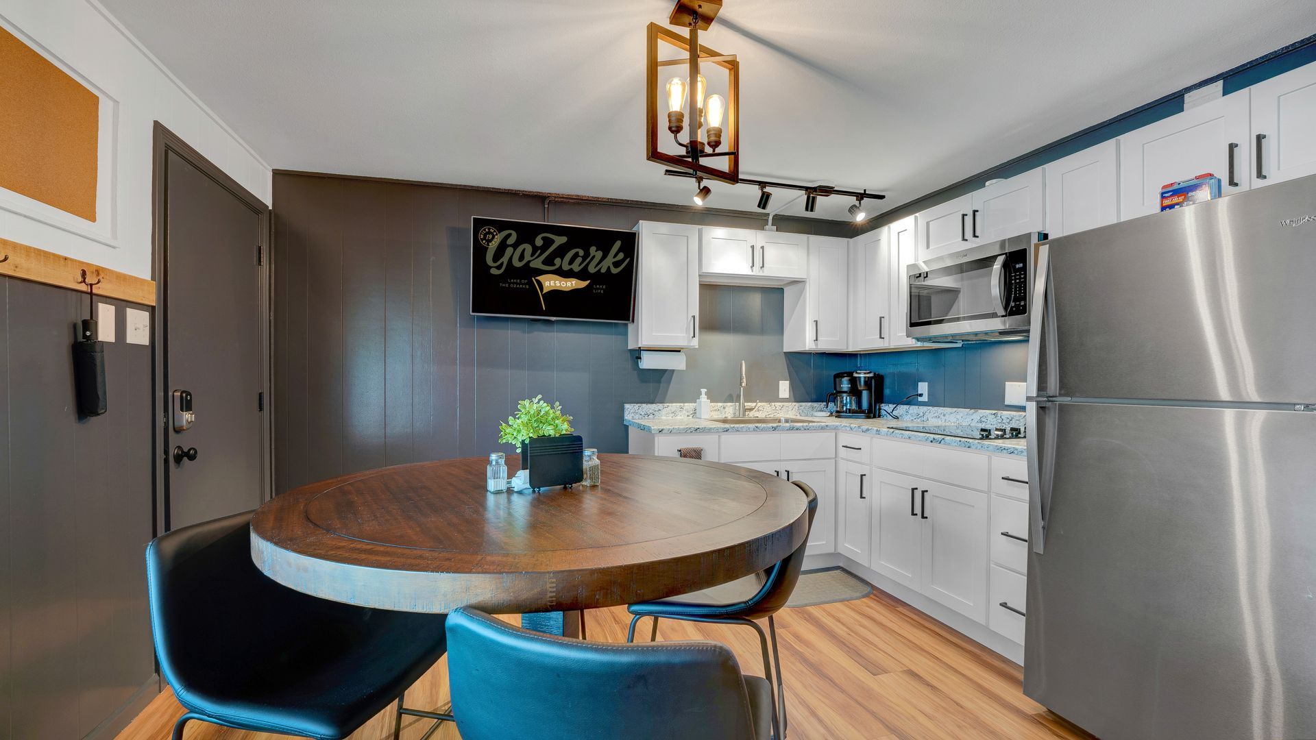 A kitchen with a table and chairs and a refrigerator.