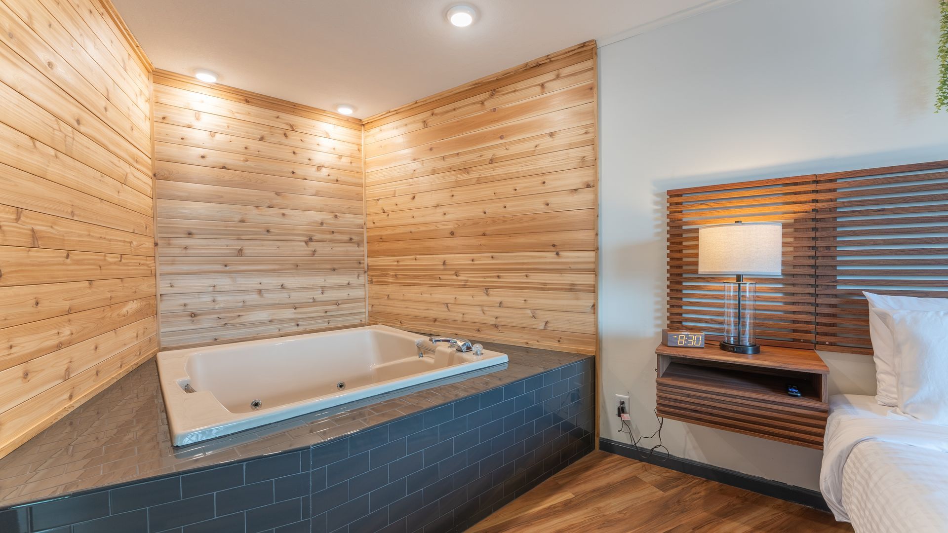 A hotel room with a jacuzzi tub in the corner.