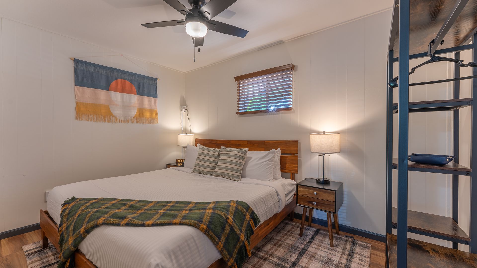 A bedroom with a king size bed and a ceiling fan.